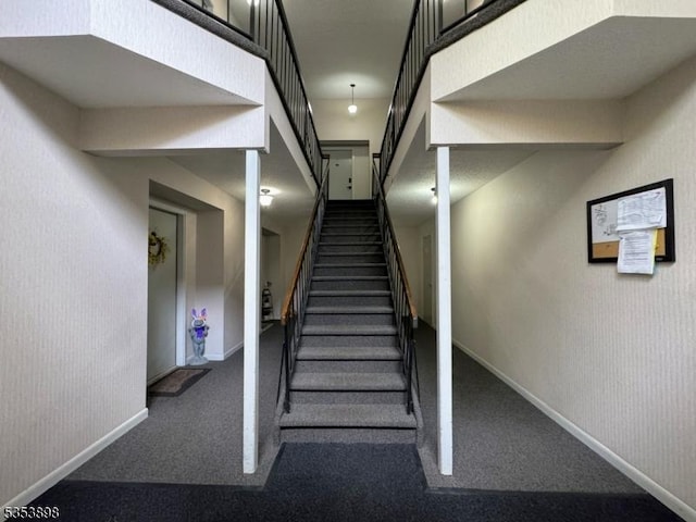 staircase with baseboards, carpet flooring, and wallpapered walls