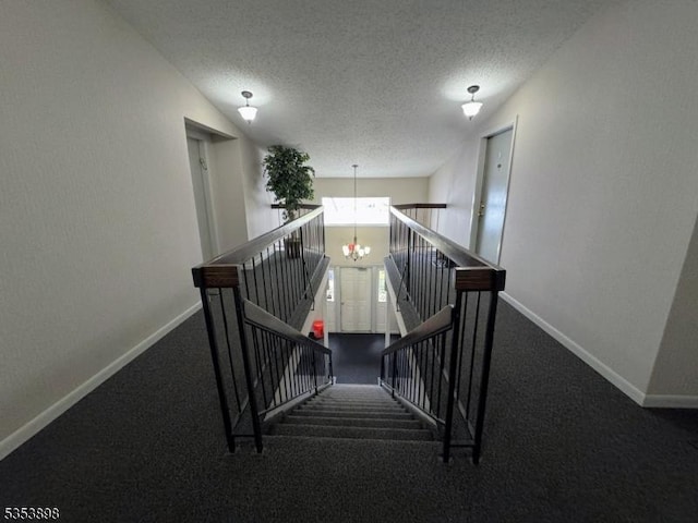 stairs with an inviting chandelier, a textured ceiling, and baseboards