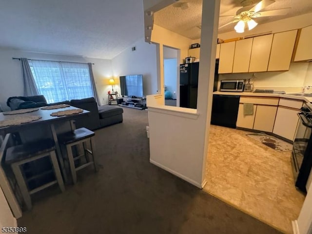 kitchen featuring open floor plan, ceiling fan, light countertops, carpet flooring, and black appliances