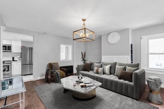 living room with an inviting chandelier and dark wood finished floors