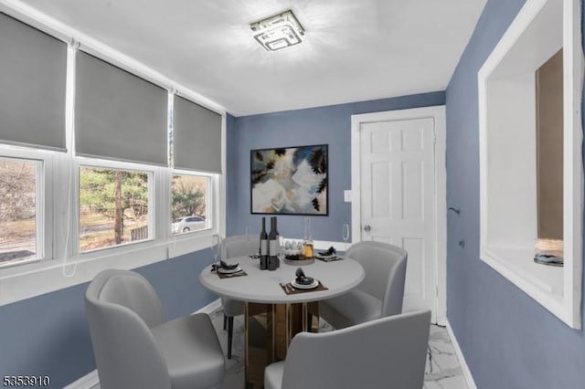 dining area with baseboards and marble finish floor