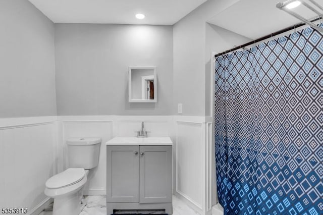 full bath featuring wainscoting, a decorative wall, toilet, and marble finish floor