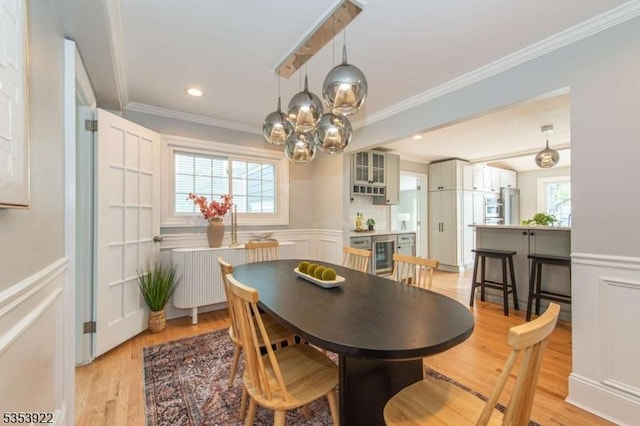 dining area with a healthy amount of sunlight, a decorative wall, and beverage cooler