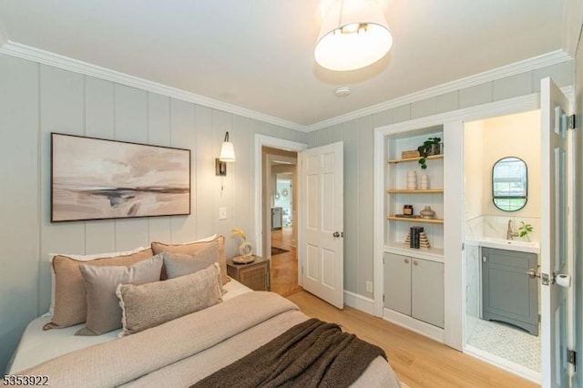 bedroom featuring crown molding, a sink, and light wood-type flooring