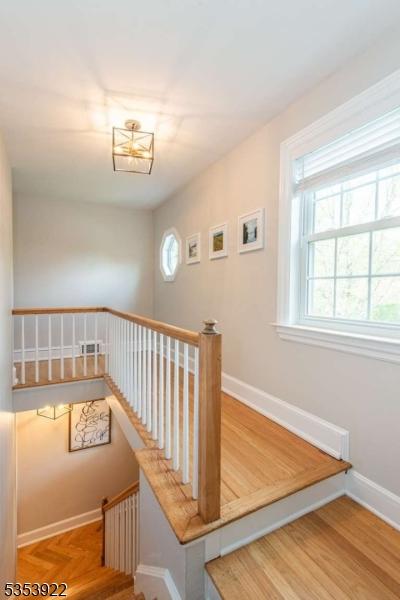 staircase featuring parquet flooring, baseboards, and plenty of natural light