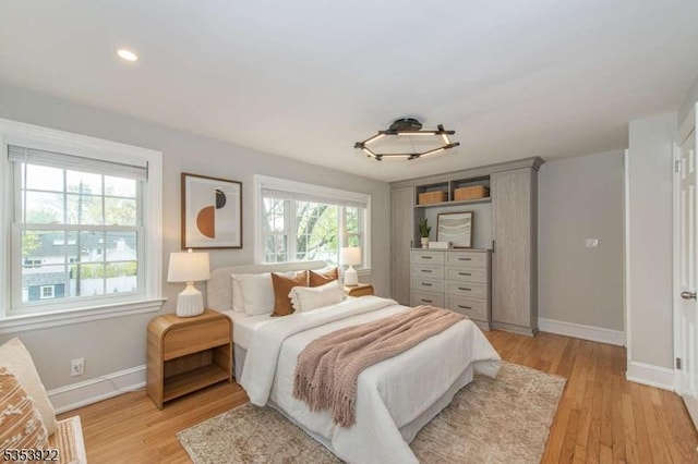 bedroom with baseboards, recessed lighting, and light wood finished floors