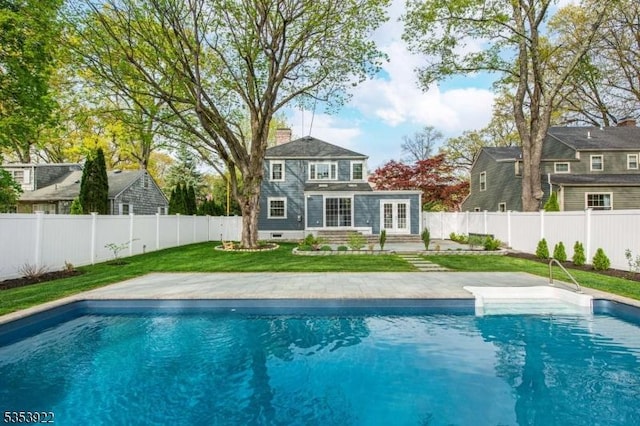 view of swimming pool featuring a yard, a fenced in pool, french doors, and a fenced backyard