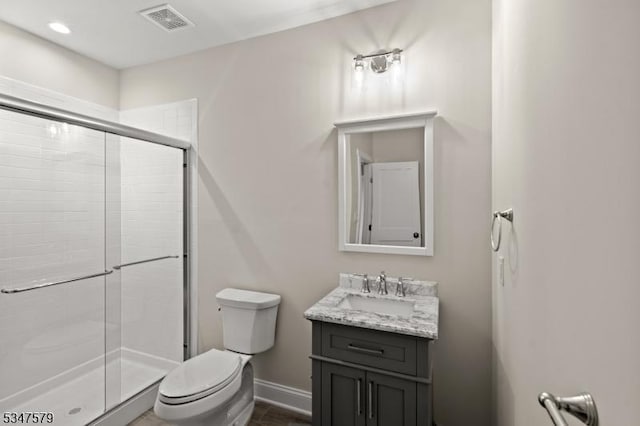 full bath with visible vents, vanity, toilet, baseboards, and a stall shower