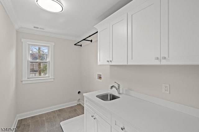 laundry room featuring ornamental molding, baseboards, hookup for a washing machine, a sink, and cabinet space