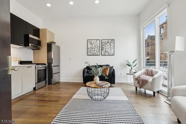 living room with dark wood finished floors, baseboards, and recessed lighting