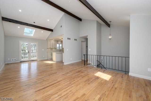 318 Sunnyside Ter, Bridgewater Twp, NJ 08807 - unfurnished living room with visible vents, beamed ceiling, baseboards, light wood-type flooring, and a skylight