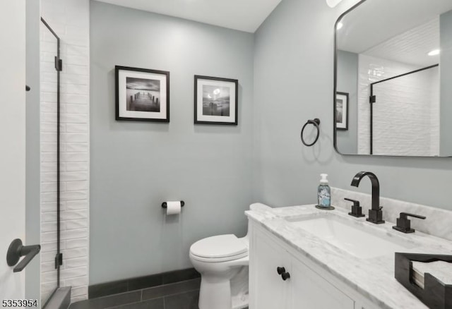 bathroom with a tile shower, tile patterned floors, toilet, and vanity