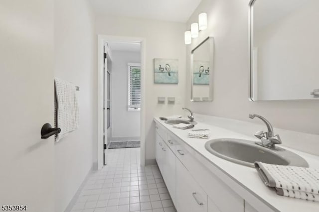 full bathroom with double vanity, tile patterned flooring, and baseboards