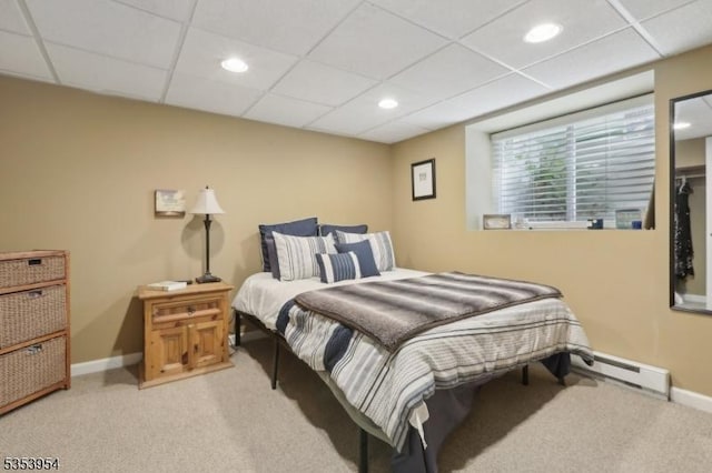 bedroom with carpet floors, a baseboard radiator, baseboards, recessed lighting, and a drop ceiling