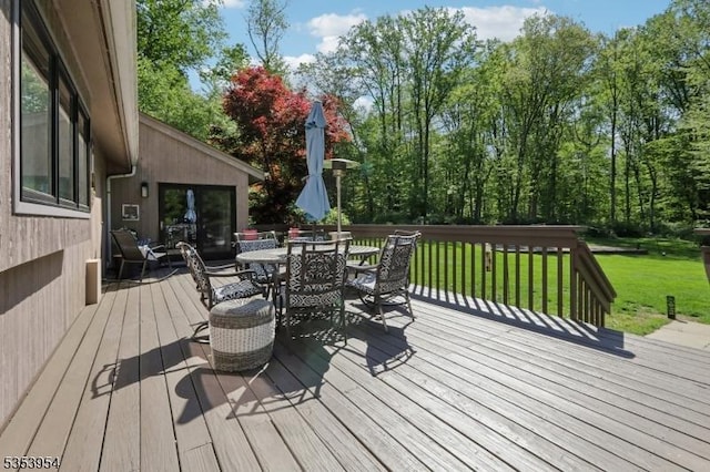 deck featuring a lawn and outdoor dining area