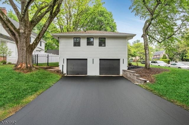 garage featuring asphalt driveway