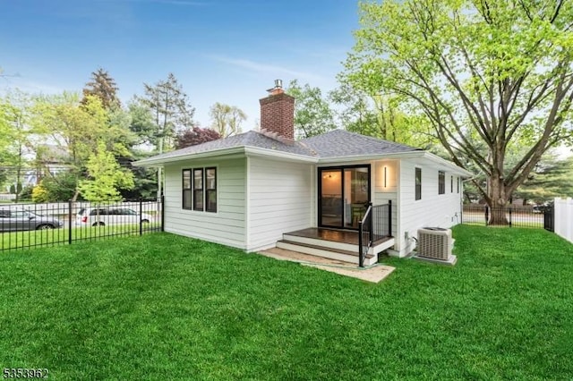 rear view of property with a chimney, cooling unit, and roof with shingles