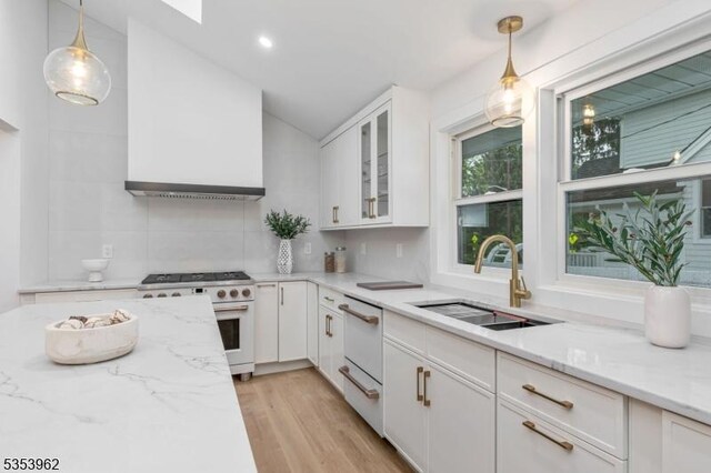 kitchen with white appliances, custom exhaust hood, a sink, lofted ceiling, and white cabinetry