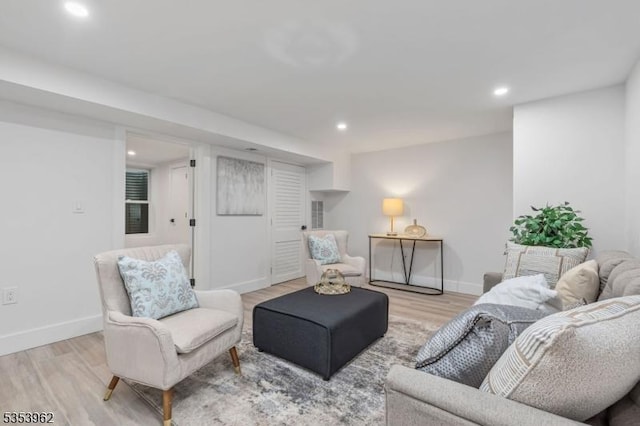living room featuring light wood-style flooring, baseboards, and recessed lighting