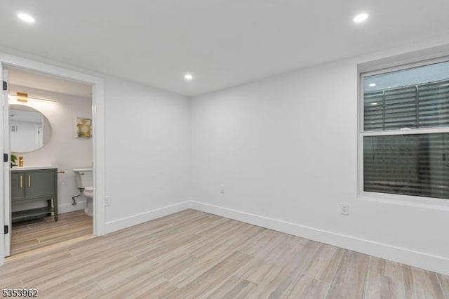 unfurnished bedroom with light wood-type flooring, recessed lighting, baseboards, and ensuite bathroom
