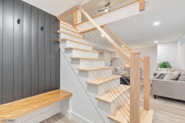 stairs with wood finished floors and recessed lighting