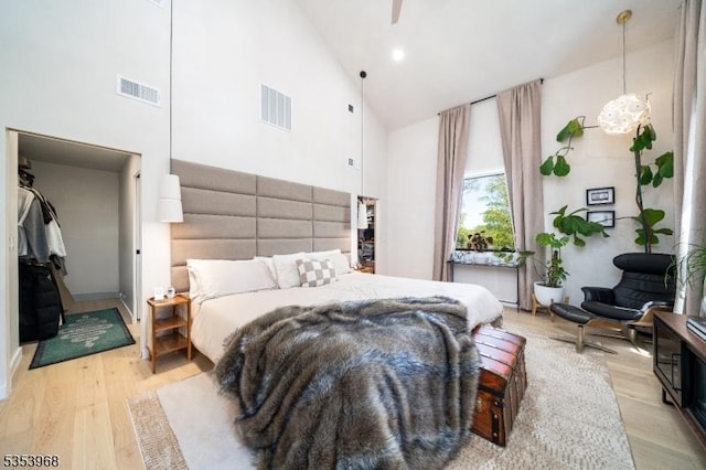 bedroom featuring high vaulted ceiling, visible vents, and light wood-type flooring