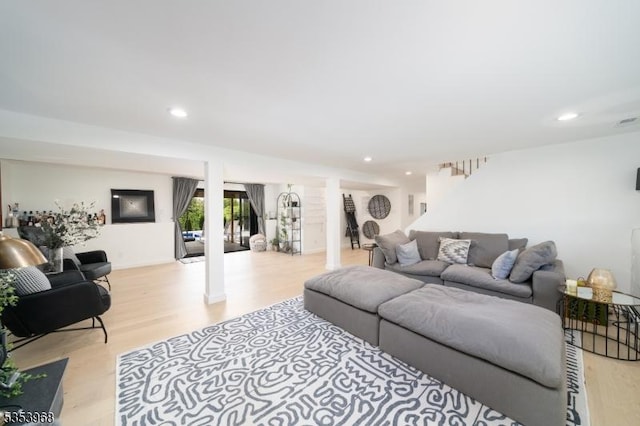 living room featuring stairs, ornate columns, recessed lighting, and light wood-style floors