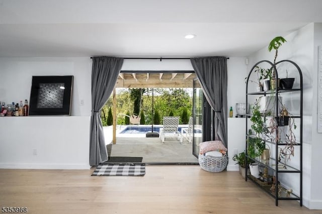 doorway with baseboards, recessed lighting, and wood finished floors