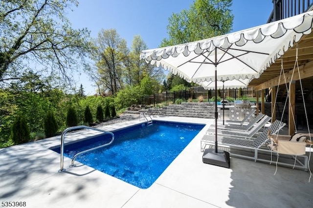 outdoor pool featuring a fenced backyard and a patio area