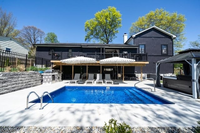 exterior space featuring fence, a patio, a gazebo, and exterior kitchen