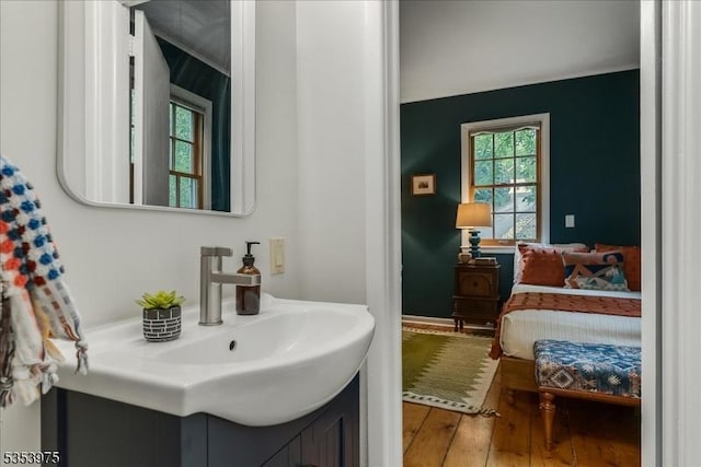 ensuite bathroom featuring hardwood / wood-style flooring and vanity