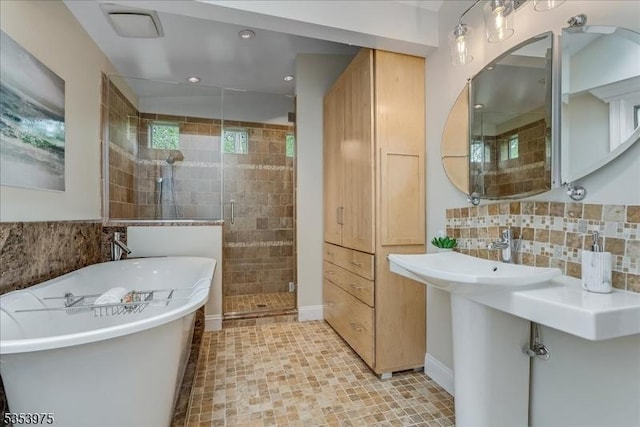 bathroom featuring a shower stall, a soaking tub, decorative backsplash, recessed lighting, and baseboards