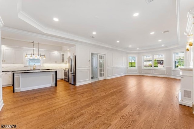 1537 Franklin St, Clark Twp, NJ 07066 - unfurnished living room with crown molding, light wood-style floors, a decorative wall, a sink, and a tray ceiling