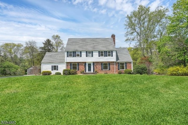 cape cod-style house featuring brick siding, a chimney, and a front lawn