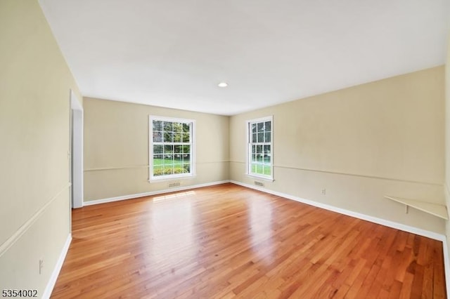 spare room with recessed lighting, baseboards, and light wood finished floors
