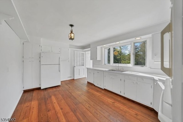 kitchen with a sink, light countertops, dark wood-style flooring, and white appliances