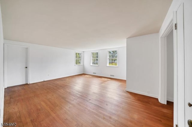 empty room with baseboards and light wood-style flooring