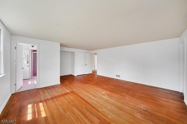 interior space featuring baseboards and light wood finished floors