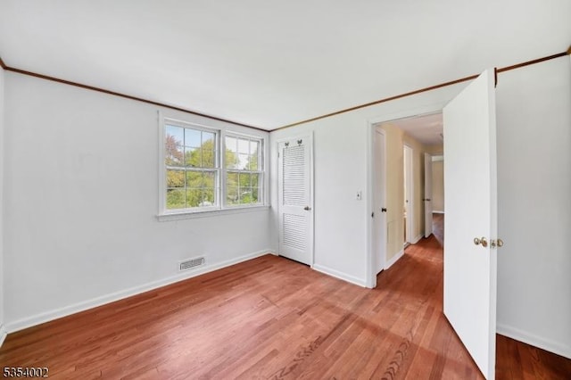 unfurnished bedroom with baseboards, visible vents, and light wood-type flooring