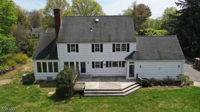 rear view of property with a lawn, a chimney, and a deck