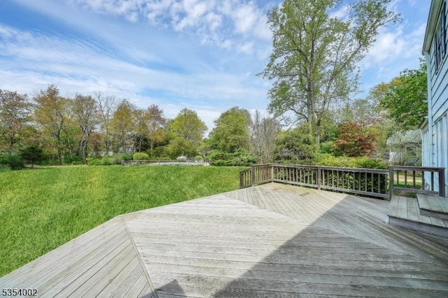 wooden terrace featuring a yard
