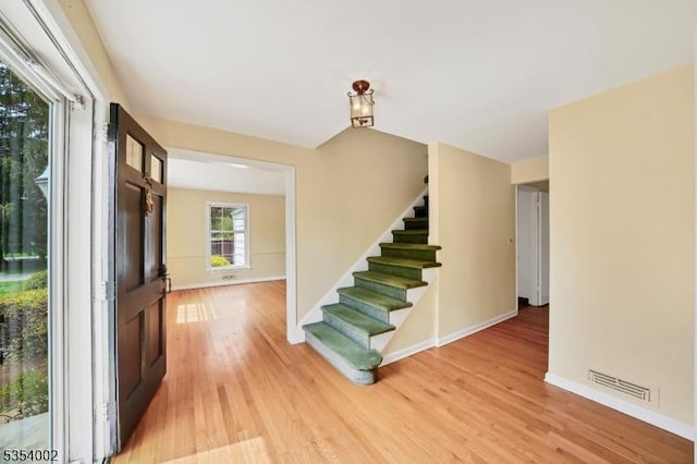 foyer featuring stairs, baseboards, visible vents, and light wood-type flooring