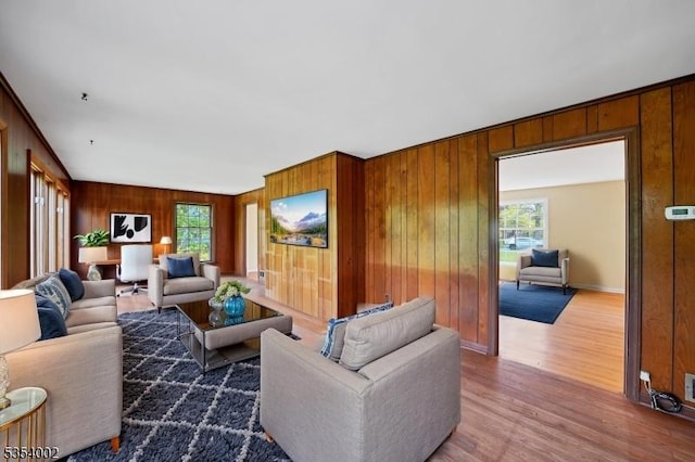 living room with wooden walls, plenty of natural light, and wood finished floors