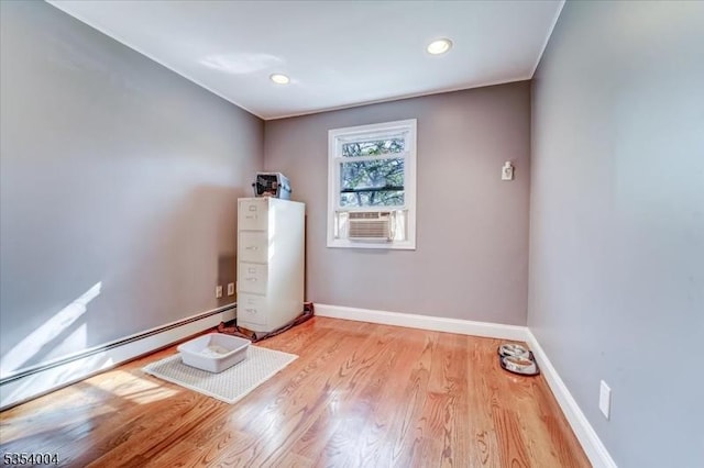 spare room featuring recessed lighting, light wood-style floors, baseboards, and a baseboard radiator