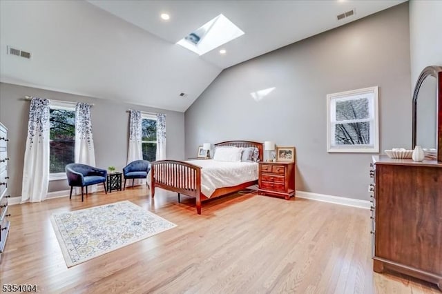 bedroom with baseboards, visible vents, light wood-style flooring, and lofted ceiling with skylight