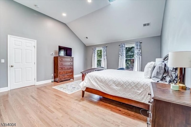 bedroom with visible vents, baseboards, vaulted ceiling, and light wood-type flooring