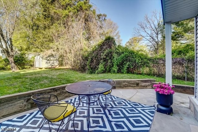 view of patio with an outdoor structure and a shed