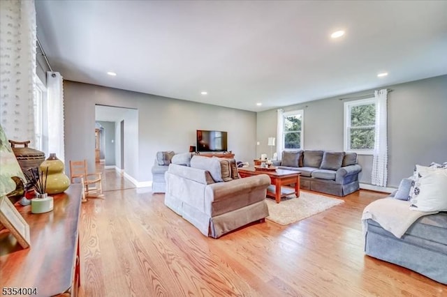 living area with recessed lighting, baseboards, and light wood-style flooring