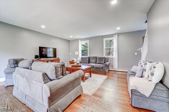 living area with recessed lighting, light wood finished floors, and a baseboard radiator