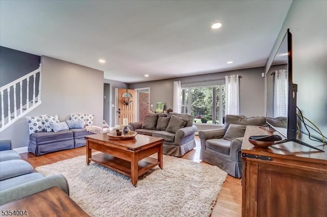 living room with stairway, recessed lighting, and light wood-type flooring